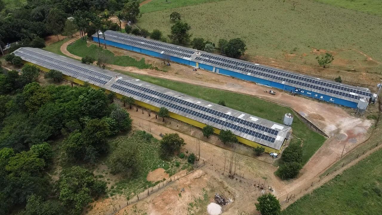Vista aérea de galpões rurais com sistema fotovoltaico instalado no telhado, projeto da NextObra